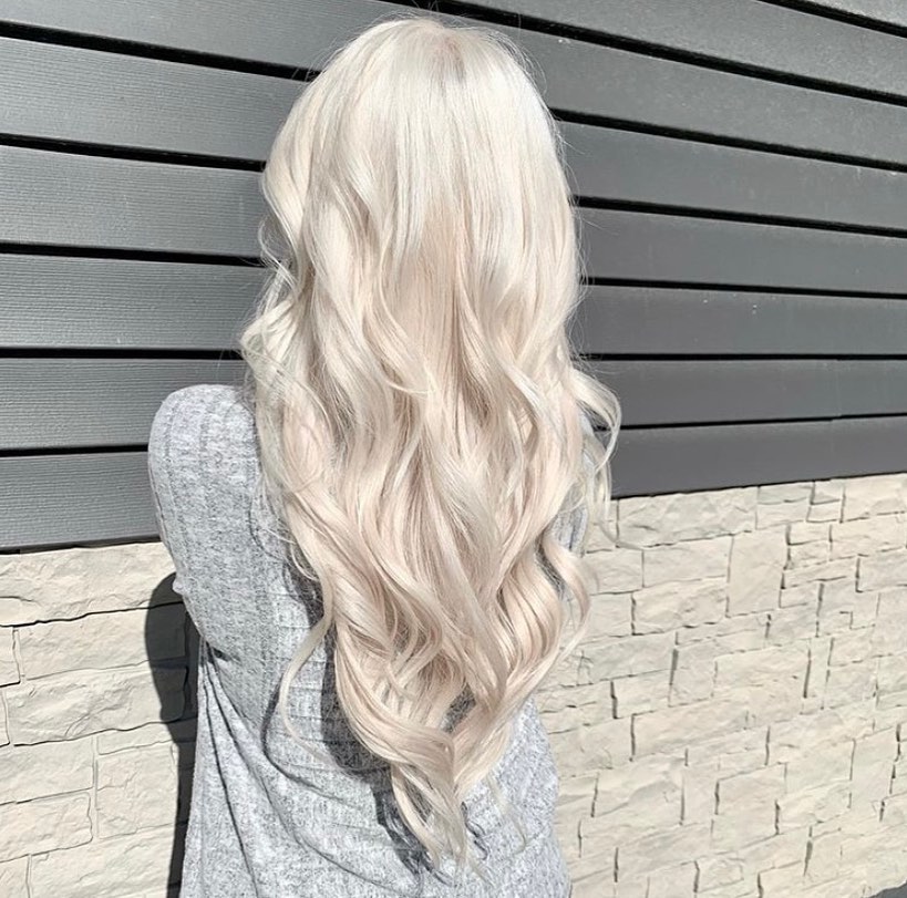 girl with blond hair extensions posing outside salons near me