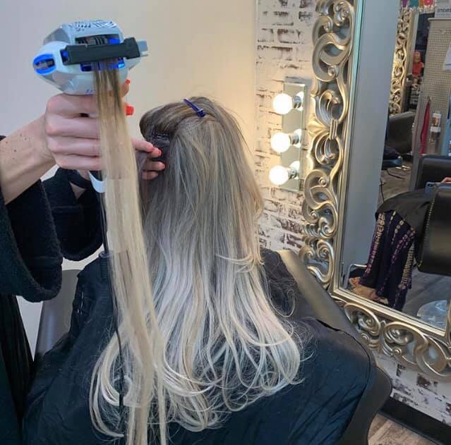 stylist installing blond hair extensions near me